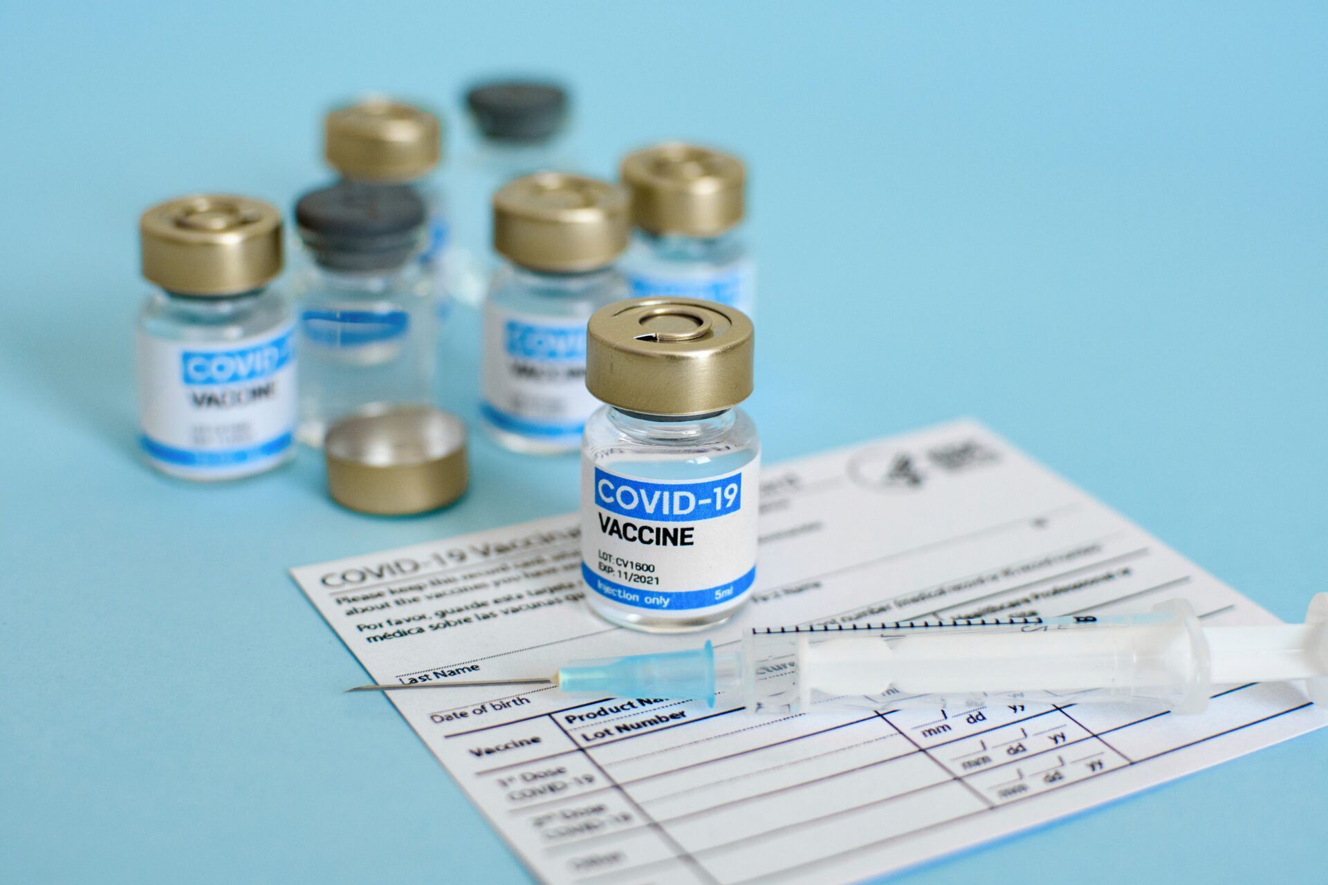 Close-up image of vaccine vial and syringe on CDC covid-19 vaccination record card